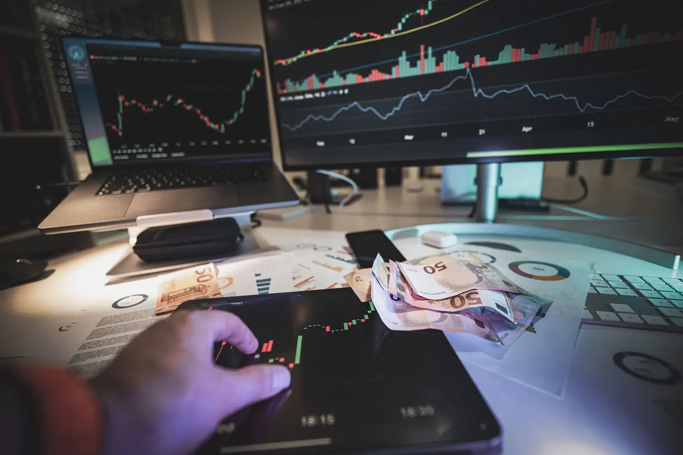 A trading desk at night with charts on two screens